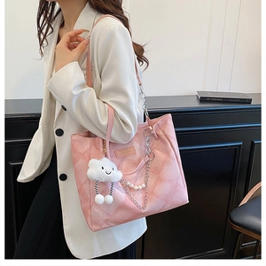 Detail of pink quilted tote bag with white cloud pendant and pearl chain shoulder strap