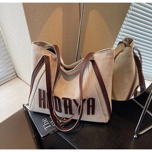 Detail of HODAYA canvas tote bag with brown leather strap and fine woven texture