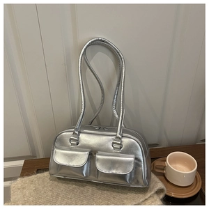 Detail of silver metallic shoulder bag with double front flap pockets and round handle