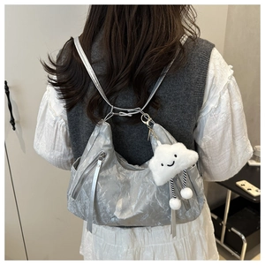 Detail of silver metallic hobo bag with thin straps and white plush cloud charm