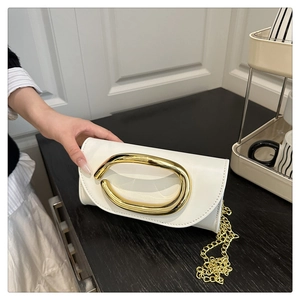 Detailed close-up of a white minimalist leather clutch with large gold oval metal buckle
