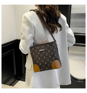 Detail showing contrast star pattern on brown bucket bag with adjustable strap and metal logo