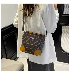 Side view of a vintage dark brown star pattern crossbody bag worn by a model