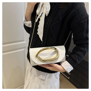 Detailed view of the sleek white leather crossbody bag with a bold gold oval buckle