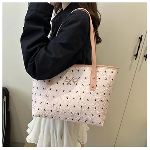 Détail du sac cabas rose en jacquard avec broderies papillons et boucle nœud dorée
