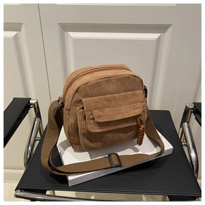 Detailed view of caramel corduroy crossbody bag with front flap pocket and adjustable strap