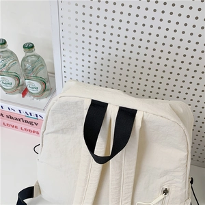Large minimalist off-white nylon backpack with side zipper pocket and black handles