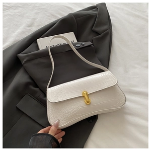 Detail of white crocodile embossed leather handbag with elegant gold U-shaped metal buckle