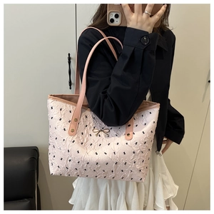 Detail of pink floral tote bag with textured ruffles and gold bow hardware