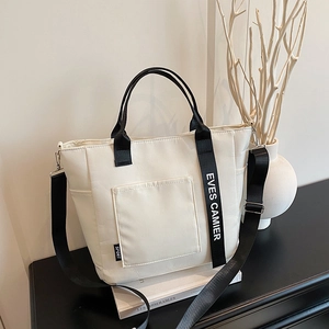 Minimalist white leather bento bag with adjustable black shoulder straps for daily office commute