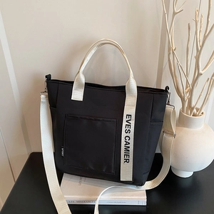 Black canvas bento lunch tote bag with sport label and contrasting cream shoulder straps