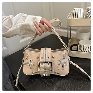 Détail du sac à main punk beige avec des rivets argentés massifs et une boucle en métal