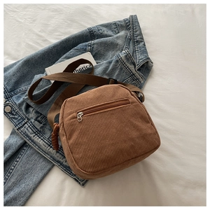 Detailed view of brown corduroy bag with rear zipper pocket and adjustable strap