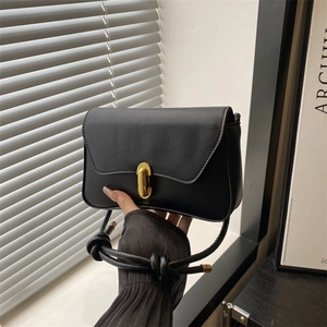 Minimalist black rectangle shoulder bag with gold oval lock and knotted strap design