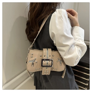 Detail view of beige retro punk shoulder bag with silver rivets and metal buckle