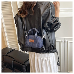 Retro denim mini crossbody bag with contrast white stitching shown on a model