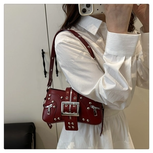 Détail d'un sac bandoulière Y2K bordeaux avec rivets argentés et boucle métallique