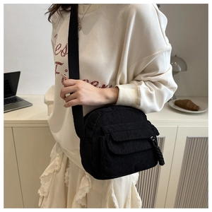Detail of vintage black corduroy crossbody bag with front flap pocket and woven zipper
