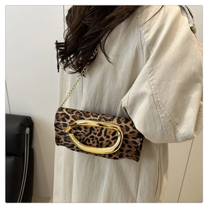 Detail of leopard print shoulder bag with oversized gold buckle and metal chain strap