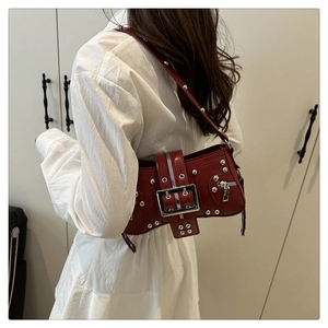Gros plan du sac bandoulière punk bordeaux avec rivets argentés et boucle métallique