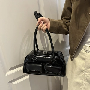 Glossy black patent leather shoulder bag with front pockets and elegant dual handles