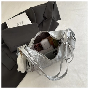 Silver wrinkled leather tote bag with fringe zipper and plush charm in minimalist style
