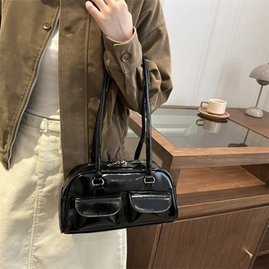 Stylish black patent leather shoulder bag with decorative pockets and silver zippers