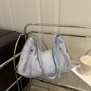 Minimalist light blue hobo tote bag in ruched fabric on a chair with coffee and magazine