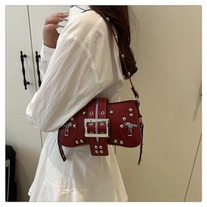 Detail view of dark red leather punk crossbody bag with silver studs and metal buckle