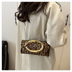 Detail of leopard print crossbody bag with gold oval clasp and elegant metal chain strap