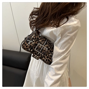 Détail du sac bandoulière léopard clouté argent porté avec un haut blanc chic