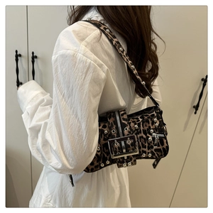 Detail of leopard print crossbody bag with silver studs and metal buckle on shoulder strap