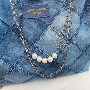 Blue denim quilted tote bag with elegant pearl embellished gold chain strap and leather tag