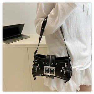 Detailed close-up of a punk-style black leather shoulder bag with silver metal rivets and buckle