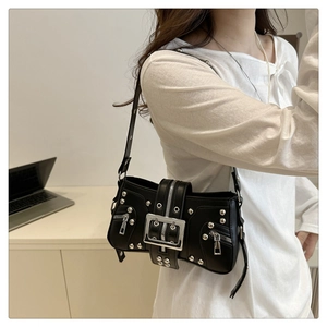 Detail of black punk shoulder bag featuring silver metal rivets and a large square buckle