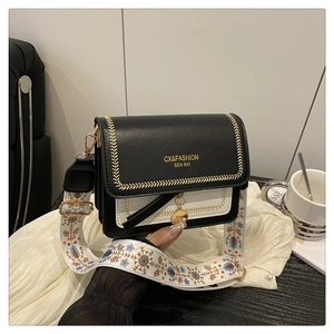 Detail of black and white contrast leather bag with vintage ethnic wide shoulder strap