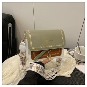Detailed view of tricolor square bag with wide jacquard strap and gold ring pendant
