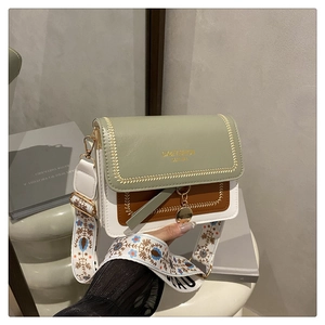 Detail of color-block bag featuring GX&FASHION gold lettering and floral embroidery strap