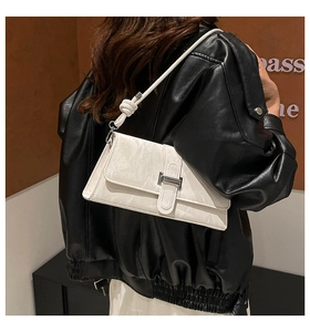 Detail of white marble textured underarm bag featuring a knotted strap and silver bar buckle