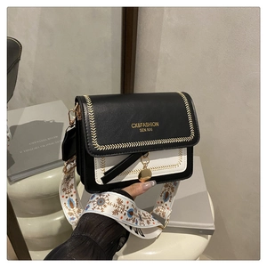 Detail of black and white crossbody bag featuring ethnic style wide embroidery strap