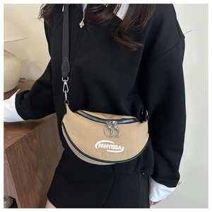 Detail of khaki crescent shoulder bag with white FANYISSA embroidery and black zipper
