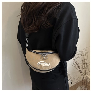 Detail of khaki crescent crossbody bag featuring black trim and white logo embroidery