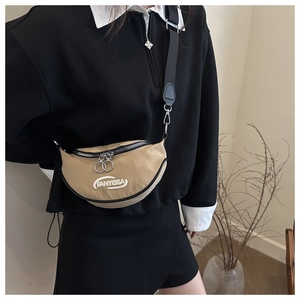 Detail of khaki crescent crossbody bag with white FANYISSA embroidery and black zippers