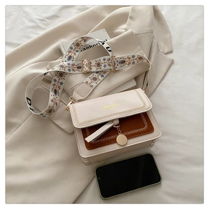 Close-up of contrast-color crossbody bag with bohemian embroidery wide shoulder strap