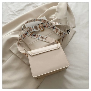 Creamy beige crossbody bag with colorful floral embroidered wide strap and gold hardware
