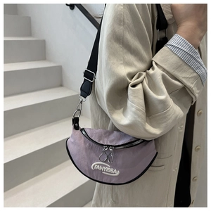 Dettaglio della borsa a mezzaluna in nylon lilla con ricamo bianco e tracolla regolabile