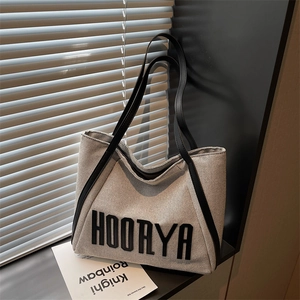 Minimalist grey canvas tote bag with black HOORYA letters and leather handles