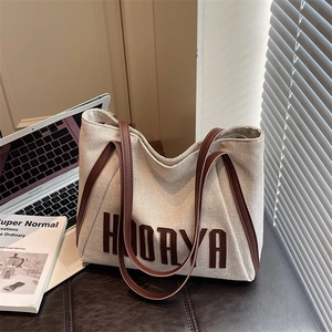 Canvas tote bag with leather straps and HOORYA print in a casual office setting
