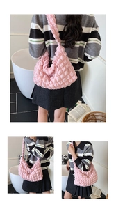 Pink bubble textured shoulder bag styled with a pleated skirt in a modern indoor setting