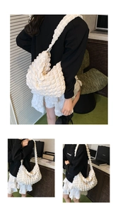 Detailed views of a white puffy bubble texture shoulder bag worn by a person in a room